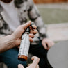 Lemon Citronella Outdoor Repellent Spray being held by two hands. 