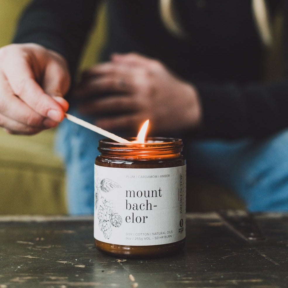 9oz Mount Bachelor Soy Candle being lit by a match. 