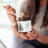 9oz Nordic Orchard Soy Candle being lit by a woman. 