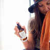 4oz Nordic Orchard Linen Spray being held by a woman.