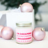 'I'm Dreaming of a Pink Christmas' 9oz Soy Candle next to pink Christmas tree ornaments. 