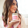 'On Christmas We Wear Pink' 9oz Soy Candle being held by a young woman.
