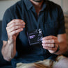 Santal Noir Car Freshener being held by a man. 