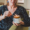 16oz Sea Salt Surf Soy Candle being lit by a match. 