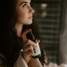 4oz Sea Salt Surf Linen Spray being sprayed by a woman. 