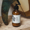 8oz Sea Salt Surf Body Lotion on a wooden bench next to a surfboard. 