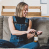 8oz Sea Salt Surf Body Lotion being used by a woman sitting on a couch. 