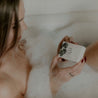 Sea Salt Surf Bar Soap being held by a woman in the bathtub. 