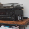 9oz Sitka Woodland Soy Candle next to a stereo system. 