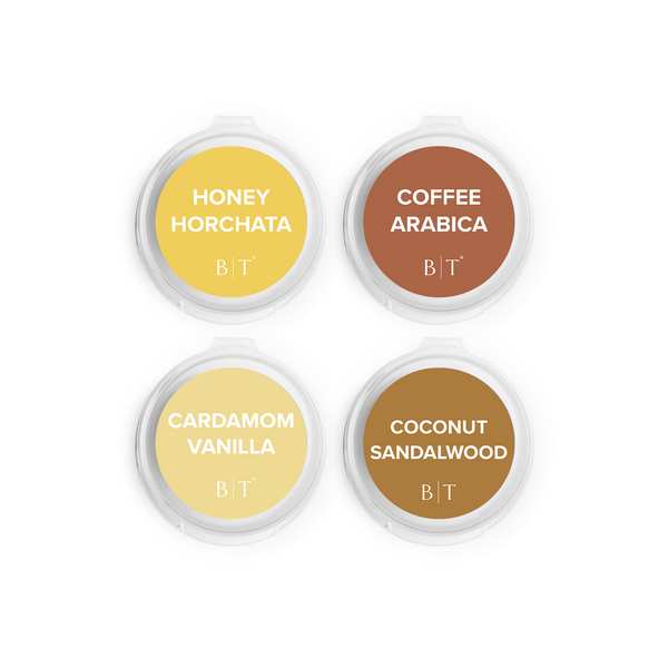 Four containers of scented candles with labels on a white background