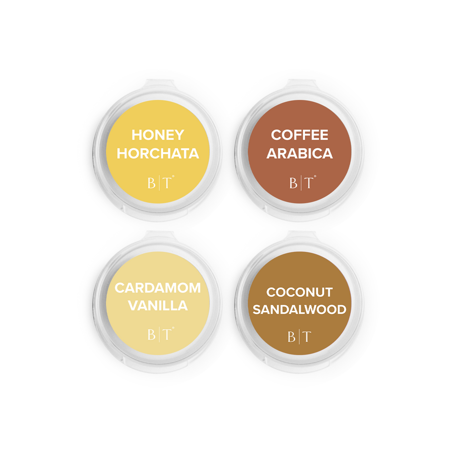 Four containers of scented candles with labels on a white background