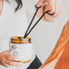 Broken Top Brands Black Wick trimmer being used to trim a candle wick. 