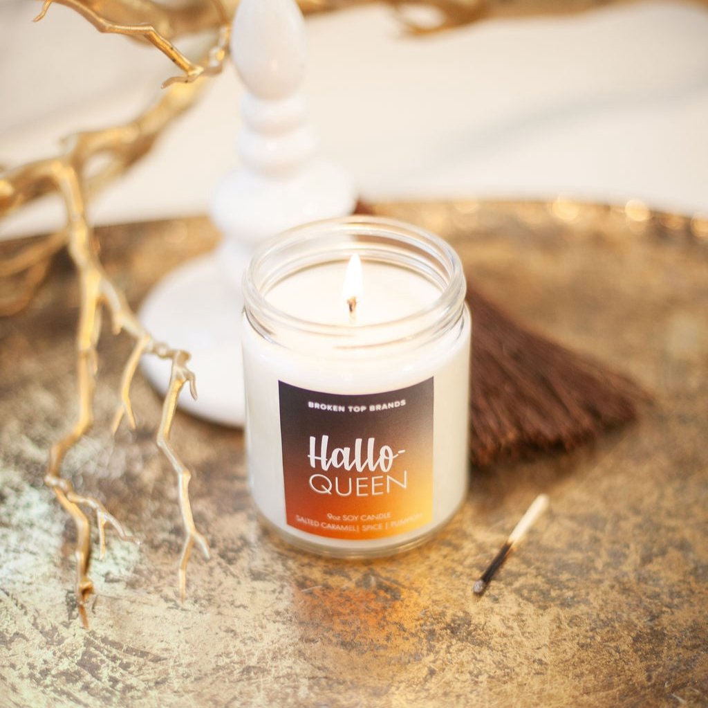 9oz 'Hallo-Queen' Soy Candle on gold table next to a match. 