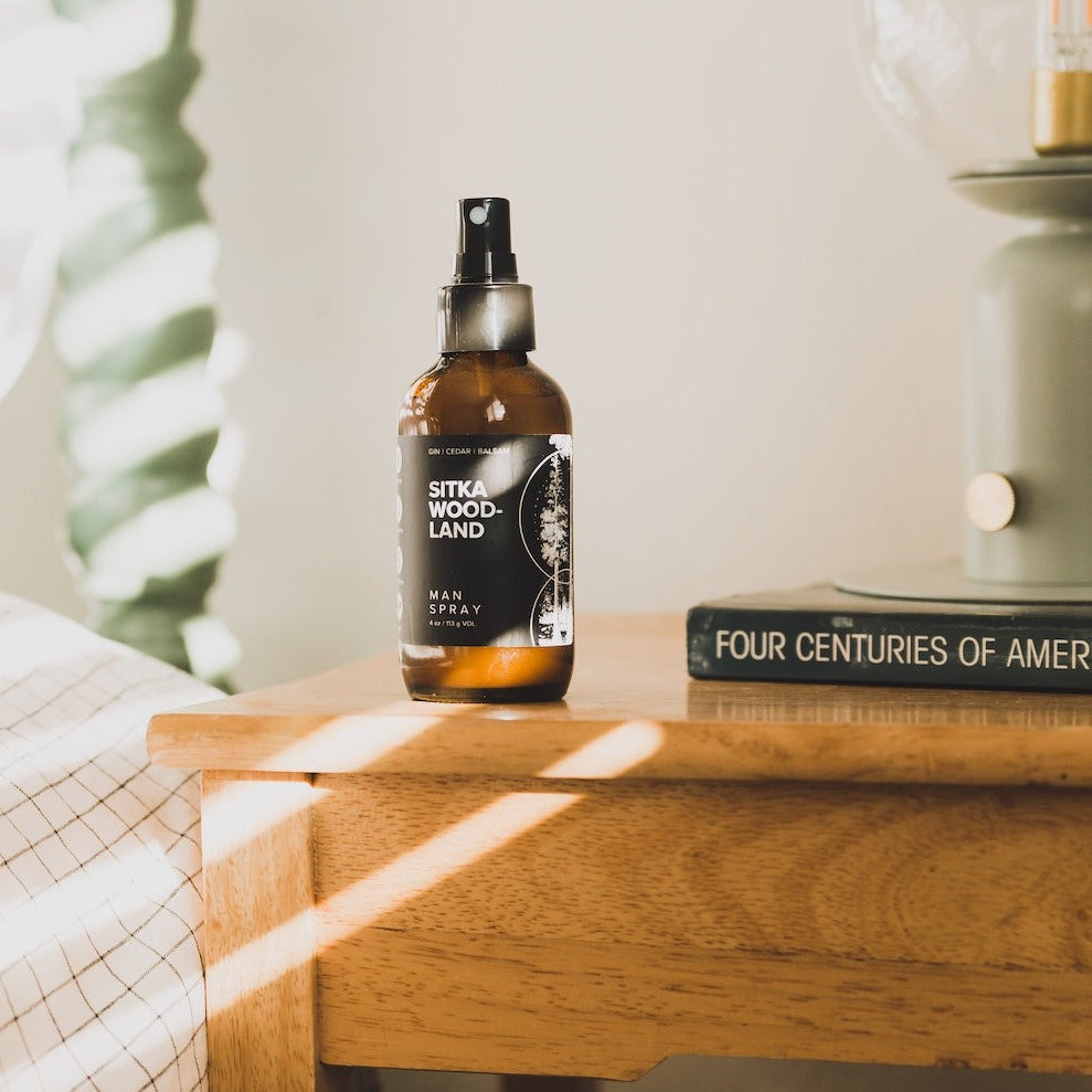 4oz Sitka Woodland Man Spray on a wooden side table. 