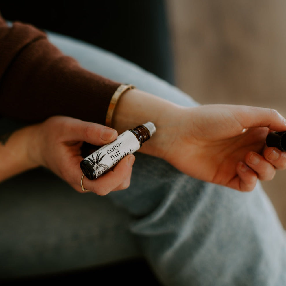 Coconut Sandalwood Roll-On Perfume being applied to a wrist. 