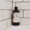 16oz Apricot Bloom Body Wash in white tiled shower. 