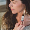 Apricot Bloom Roll-On Perfume being applied to woman's neck. 