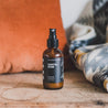 4oz Santal Noir Man Spray on a wooden bench. 