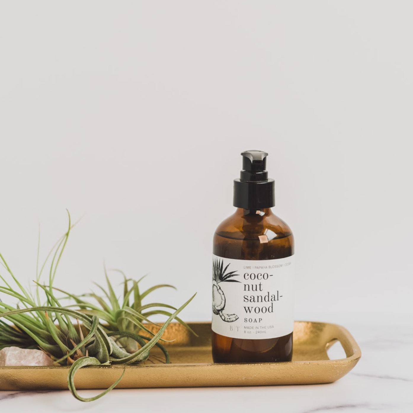 8oz Coconut Sandalwood Liquid Soap on a gold tray. 