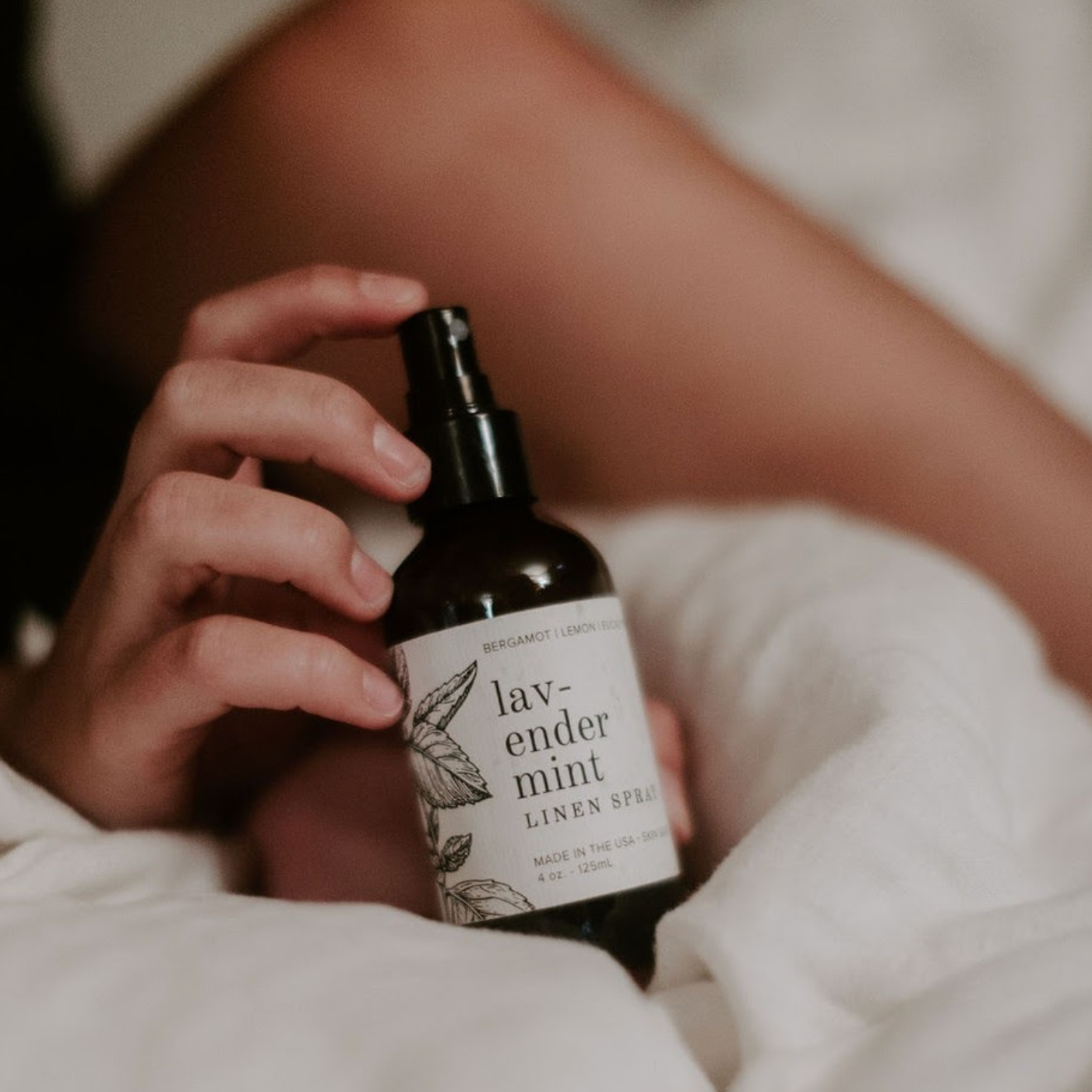 4oz Lavender Mint Linen Spray being held by a hand. 