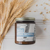 9oz Wild Blue Grass Soy Candle next to dried wheat. 